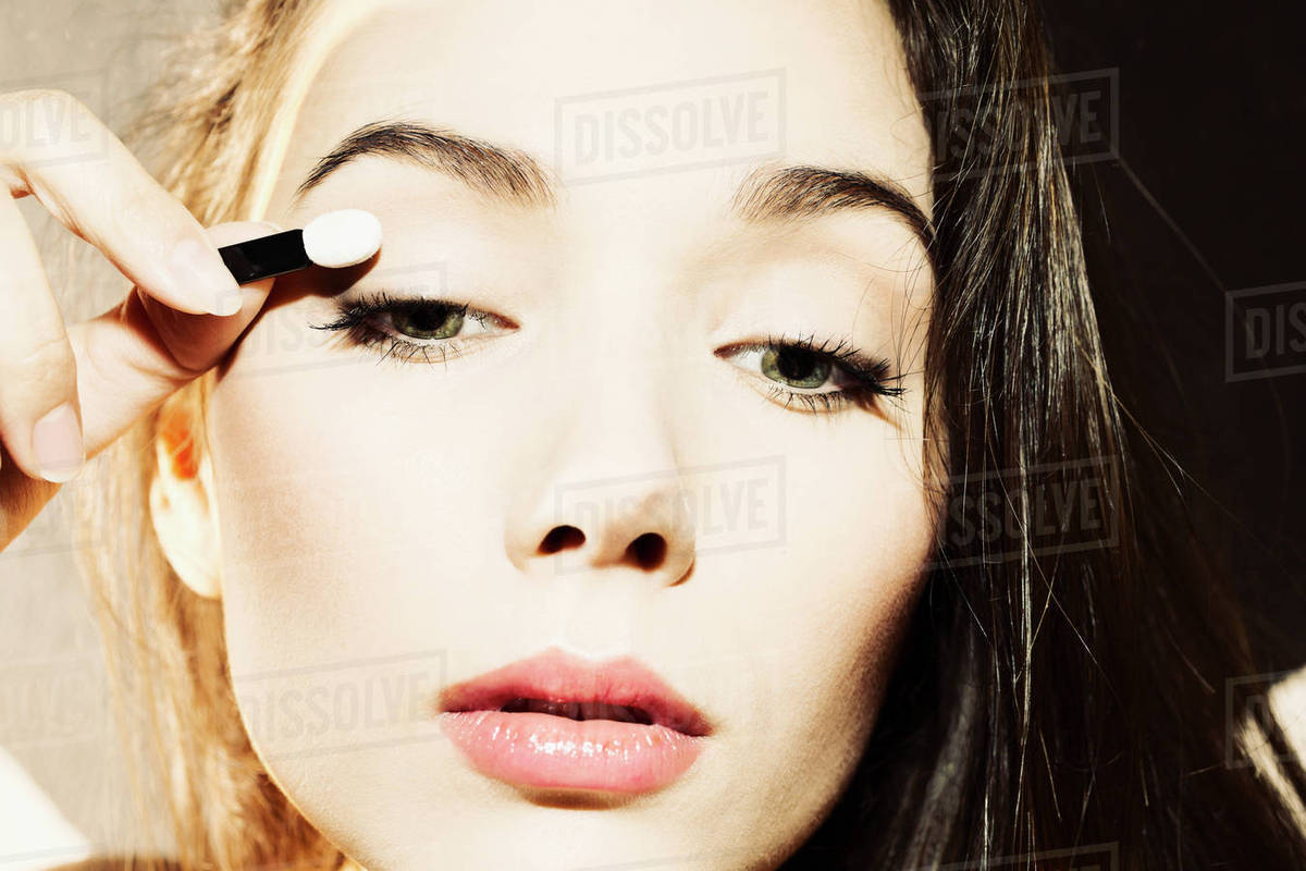 Close-up of young woman applying makeup Rights-managed stock photo
