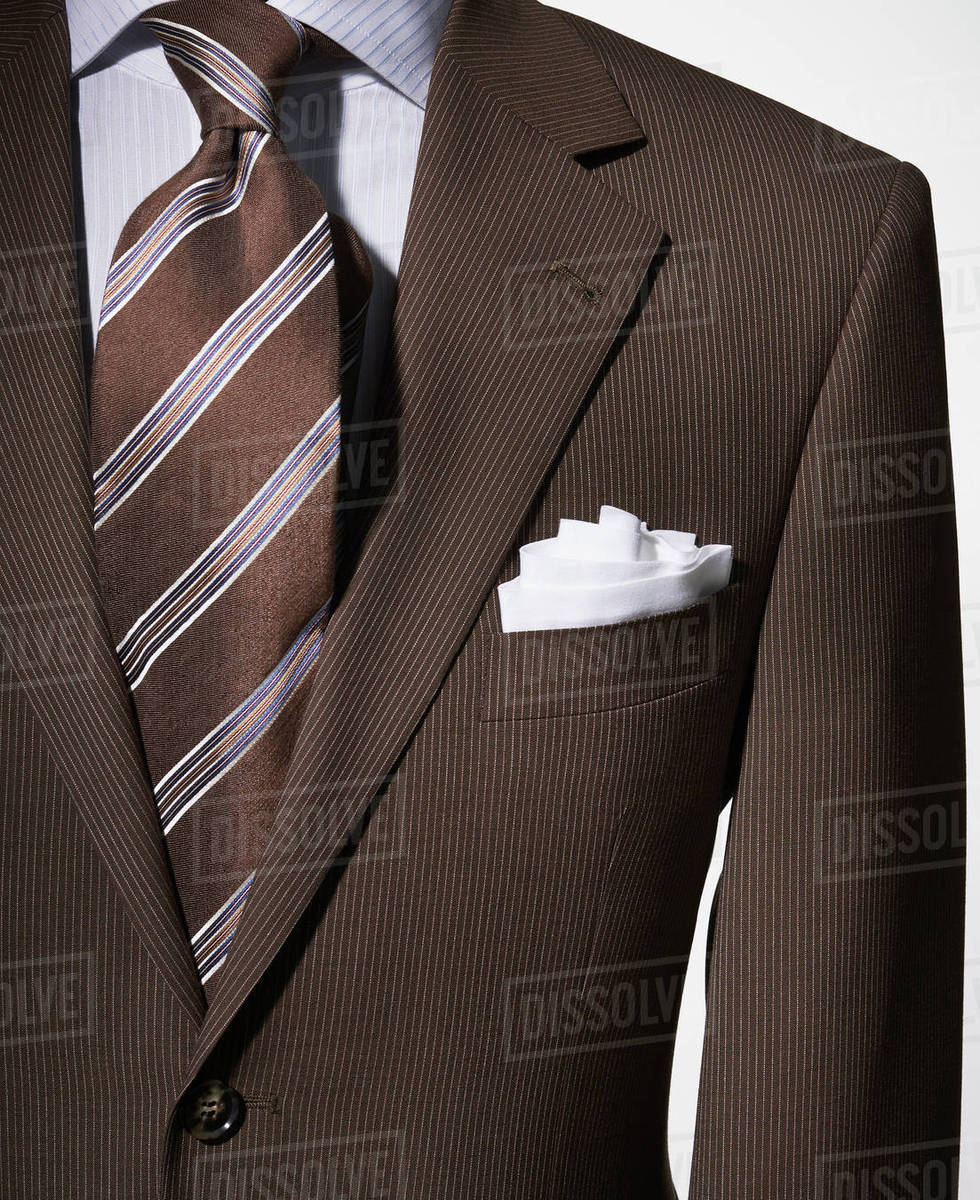 Detail of a bown suit jacket with shirt, white handkerchief and brown
