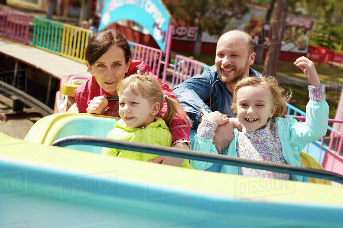 Family of four having fun in amusement park Royalty-free stock photo