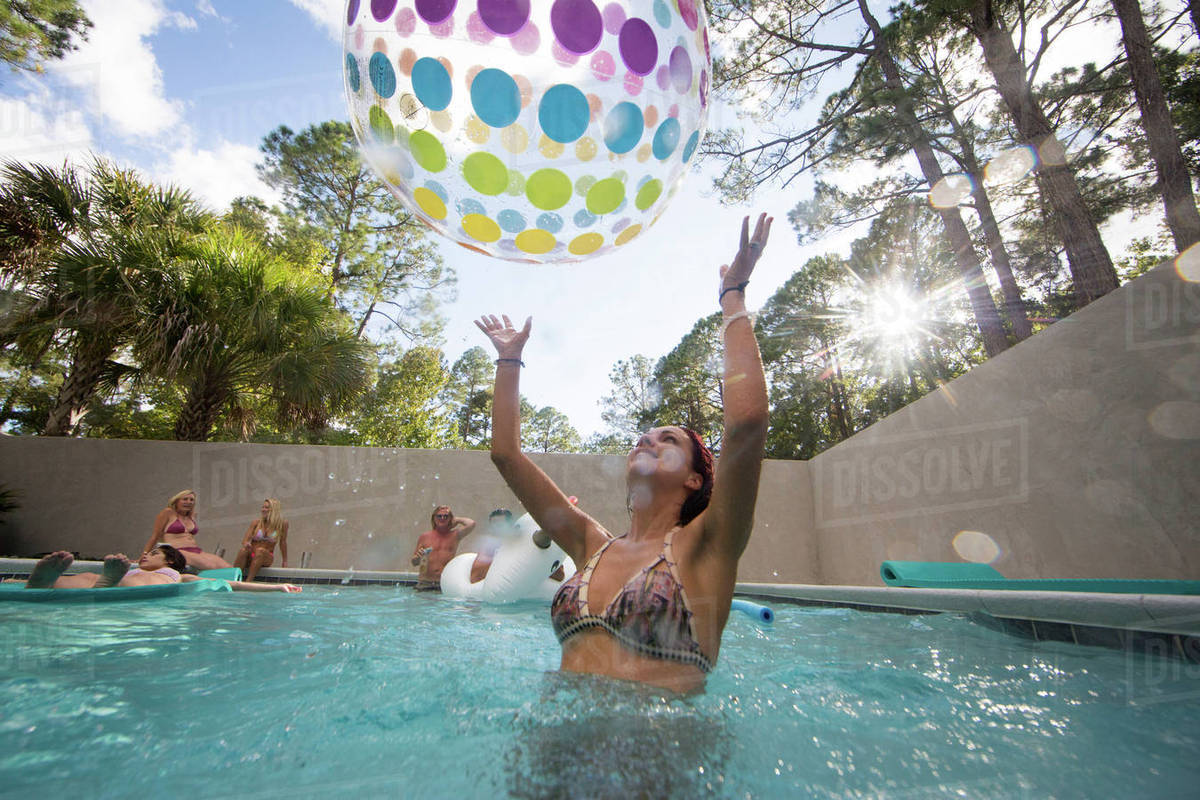 Woman playing throwing beach ball in swimming pool, Santa Rosa Beach, Florida, USA Royalty-free stock photo
