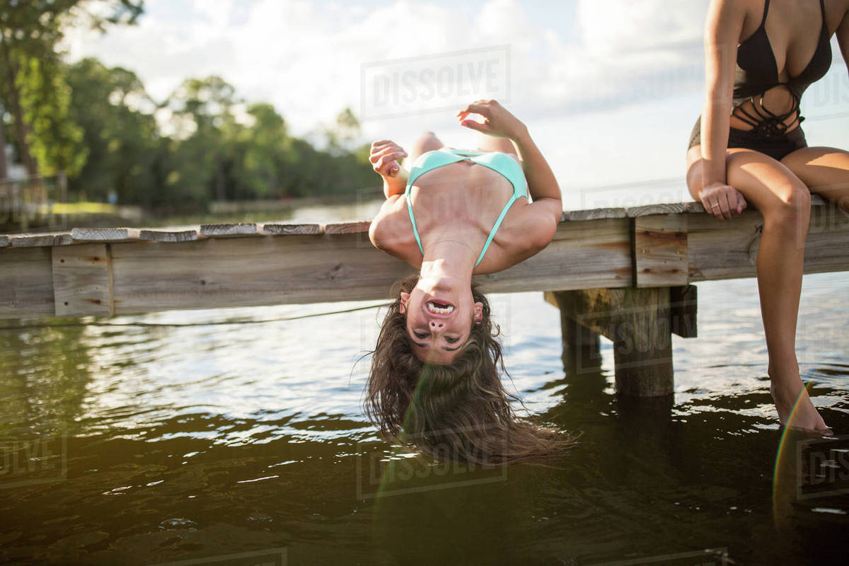 Young woman lying back on pier dangling long wet hair, Santa Rosa Beach, Florida, USA Royalty-free stock photo