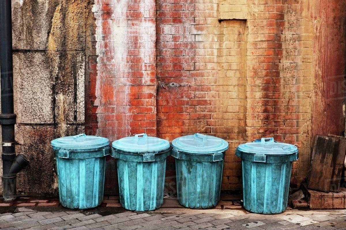 Garbage Cans Lined Up Along A Wall In An Alley; Tokyo, Japan Stock