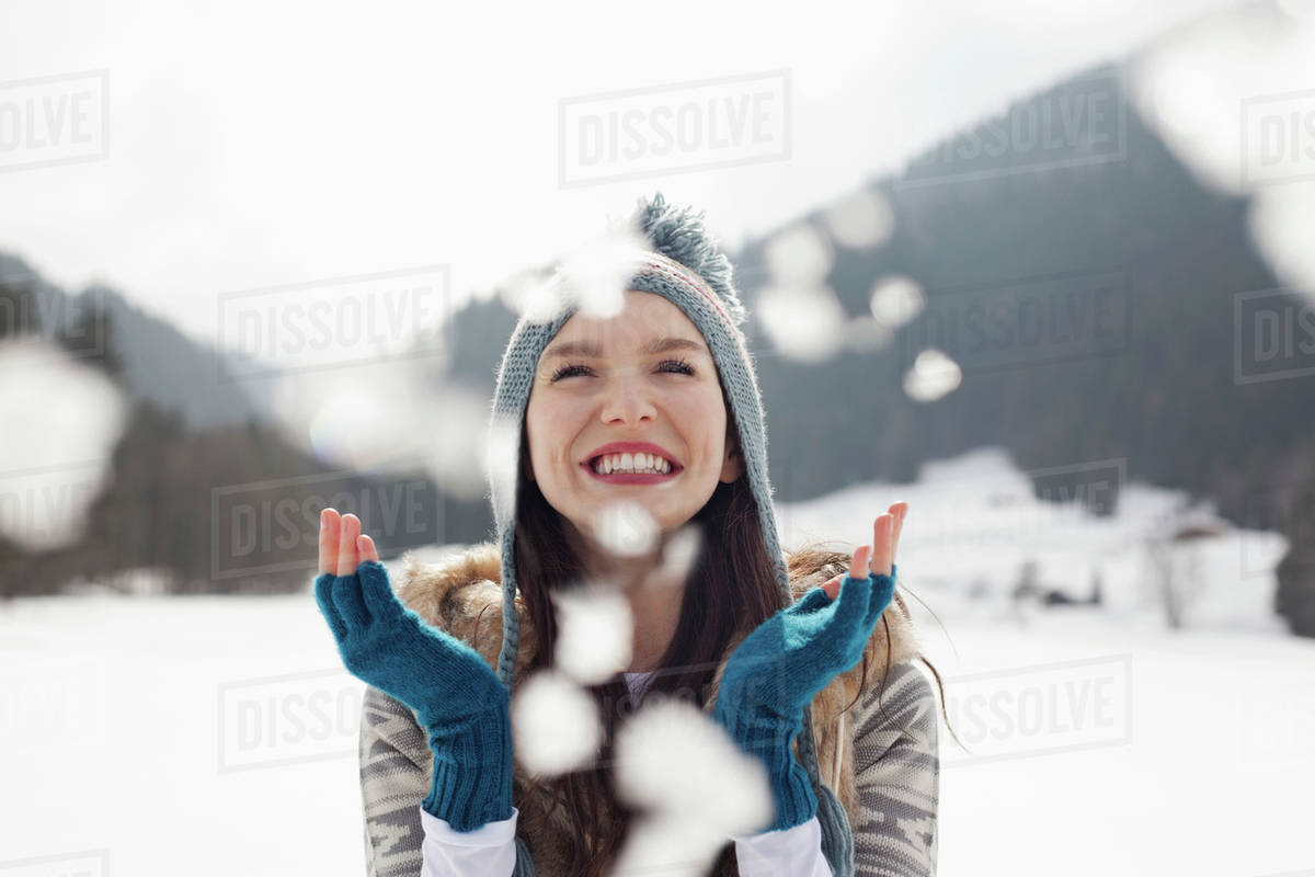 Happy woman enjoying falling snow in field Royalty-free stock photo